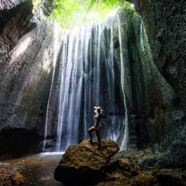 Beautiful woman standing in front of Tukad Cepung Waterfall